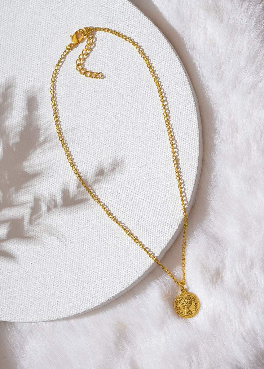 Gold Necklace on White Textile